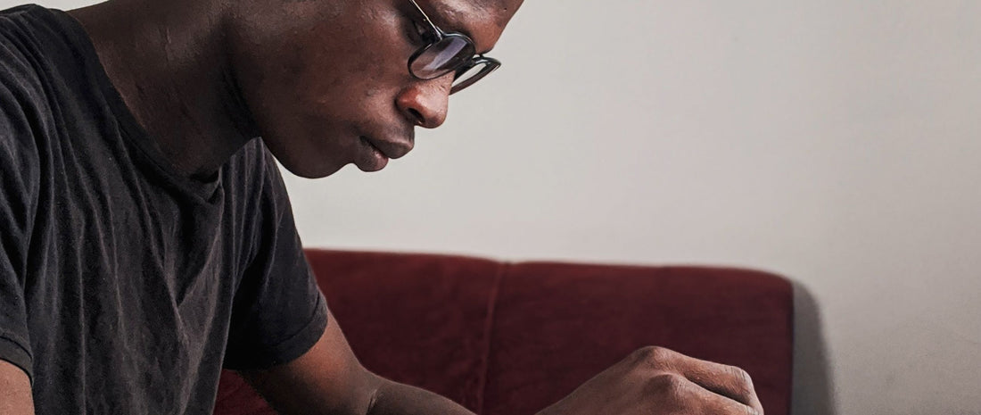 Adult learner wearing headphones and taking notes while practising for an A-Level language listening exam